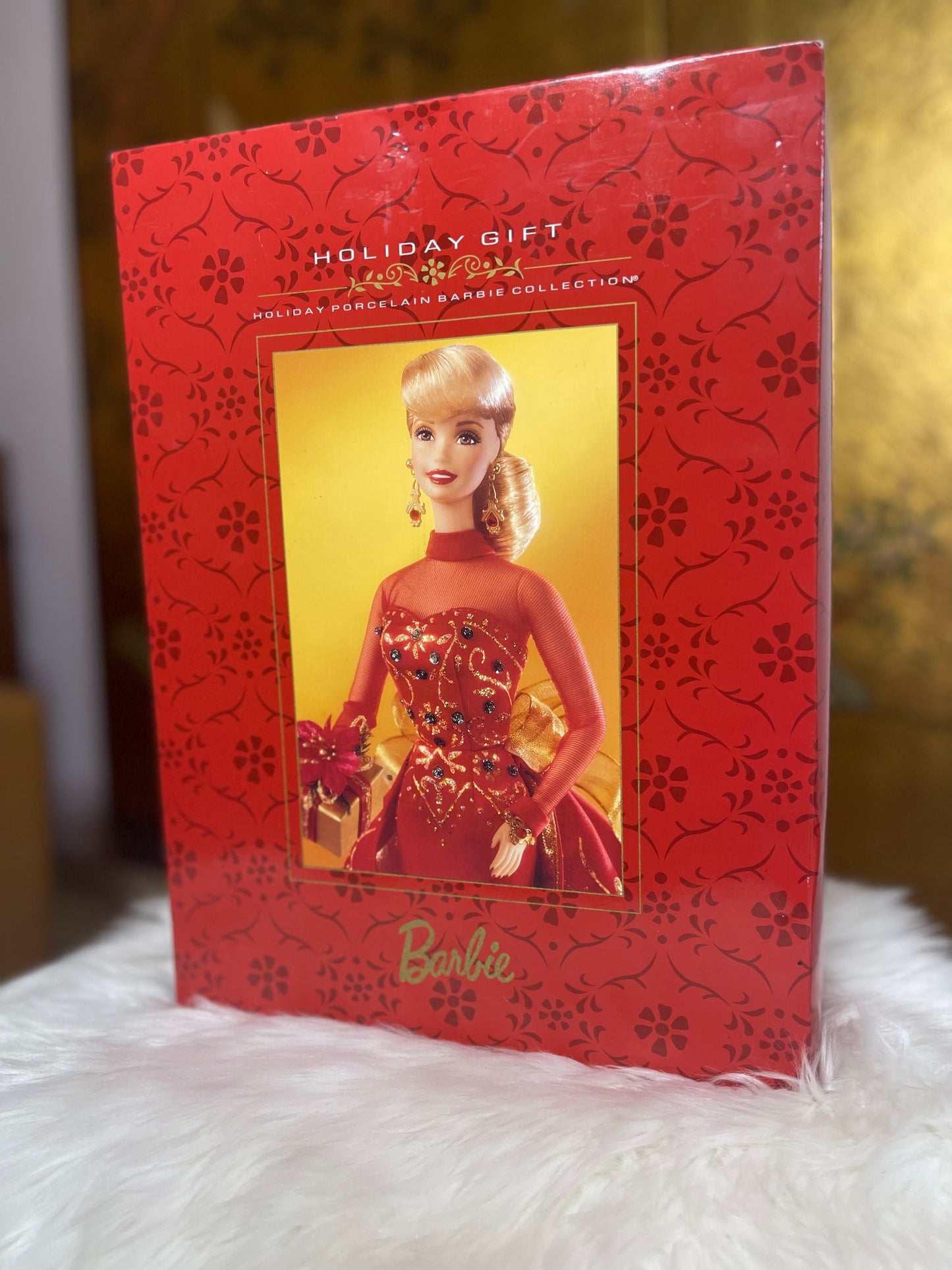 Beautiful Limited edition Holiday barbie New in box. the Holiday red box shows the a photo of the porcelain barbie inside with a red dress and elegant holiday hairstyle ready for Christmas gifting.